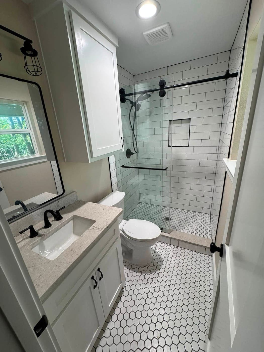 Hall bathroom after remodel — subway tile walk-in shower, hex floor