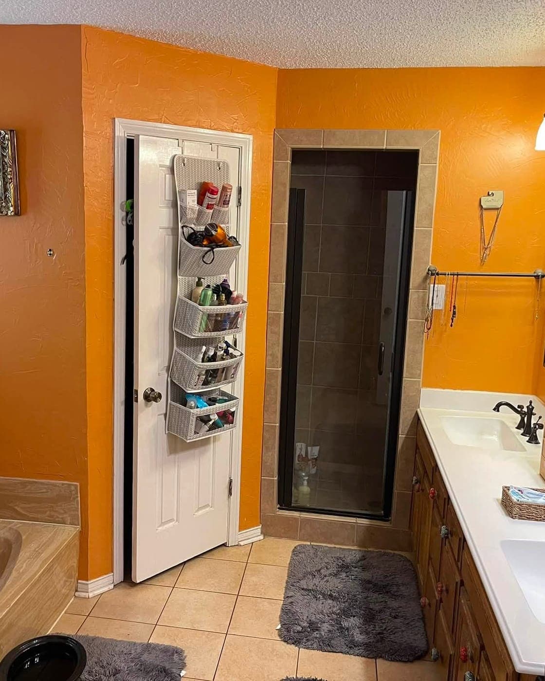 Master bathroom before remodel — dated orange walls and dark shower